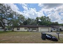 Charming single-story home with a combination of siding and stone accents and a well-maintained lawn at 401 Pine Dr, Sanford, FL 32773