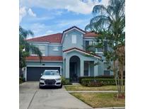 Charming two-story home with a well-manicured lawn and a driveway leading to an attached garage at 1030 Marcello Blvd, Kissimmee, FL 34746