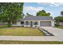 Charming one-story home featuring a well-maintained lawn, brick exterior, and a cozy front entrance at 520 Hamlet Dr, Port Orange, FL 32127
