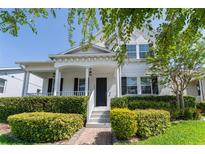Charming two-story home with a welcoming front porch and lush landscaping, complete with a neatly manicured lawn at 14563 Bahama Swallow Blvd, Winter Garden, FL 34787