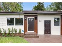 Charming home featuring a decorative front door, well-maintained landscaping, and modern architectural details at 2013 Pineway Dr, Orlando, FL 32839
