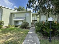 A charming, two-story condo building with a beautifully landscaped yard and an inviting walkway entrance at 568 Bahia Cir # B, Ocala, FL 34472