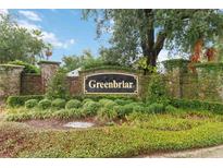 Landscaped Greenbriar community entrance sign with brick pillars covered in climbing ivy at 13219 Meadowlark Ln, Orlando, FL 32828