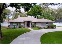 Beautiful single-story home with a manicured lawn, curved driveway, and elegant facade at 1634 Lady Bowers Trl, Lakeland, FL 33809