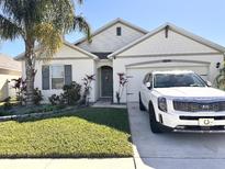 Charming single-story home with manicured lawn, mature palm tree, and a white SUV in the driveway at 2987 Neverland Dr, New Smyrna Beach, FL 32168