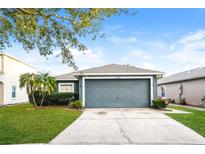 Charming single-story home featuring a manicured lawn and a two-car garage at 2216 Heathwood Cir, Orlando, FL 32828