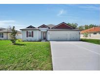Charming single-story home with a two-car garage and a well-manicured lawn on a sunny day at 2649 Sw 176Th Loop, Ocala, FL 34473
