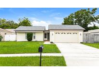 Well-maintained single-story home featuring a manicured front lawn and a two-car garage at 408 S Edgemon Ave, Winter Springs, FL 32708