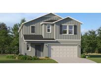 Two-story home with vertical siding, black shutters, and a two-car garage on a well-maintained lawn at 3414 Howell Dr, Lake Wales, FL 33859