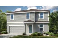 Charming two-story home with a combination of gray siding and stone, complemented by a well-manicured lawn at 2302 Cypress Creek St, Auburndale, FL 33823