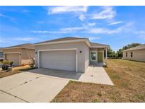 Charming single-story home featuring a well-manicured lawn and a two-car garage with neutral color palette at 3184 Whispering Trails Ave, Winter Haven, FL 33884