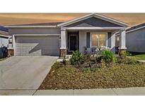 Charming single-Gathering home featuring a well-maintained front yard and attached garage at 590 Tanaro Ln, Haines City, FL 33844