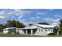 Charming single-story home featuring light blue siding, a metal roof and a covered porch at 149 County Road 640, Lake Wales, FL 33859