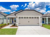 Charming single-Gathering home featuring a two-car garage, manicured lawn, and welcoming front porch on a sunny day at 3832 Corsican Pl, Lake Alfred, FL 33850