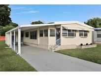 Well-maintained single-story home with a covered carport and lush green lawn at 1610 Reynolds Rd # 5, Lakeland, FL 33801