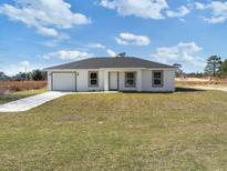 Charming single-story home featuring a neatly manicured lawn and attached one car garage at 2680 Sw 144 Ct, Ocala, FL 34481