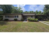 Charming single-story home featuring a carport, well-maintained lawn, and fresh landscaping at 2818 Dellwood Dr, Orlando, FL 32806