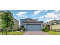 Charming two-story home featuring a two-car garage and a well-maintained front yard at 6889 Wilson Hammock Ave, Groveland, FL 34736
