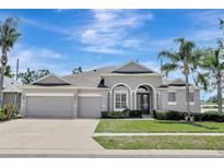 Charming single-story home featuring a three-car garage, arched entryway, and manicured landscaping at 13708 Old Dock Rd, Orlando, FL 32828
