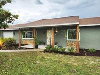 Charming single-story home featuring a quaint front porch with decorative plants and lush landscaping at 4727 Wales St, Lake Wales, FL 33859
