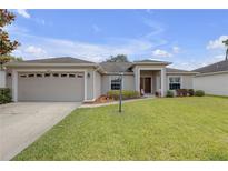 Charming single-story home featuring a well-manicured lawn, attached two car garage, and welcoming front entrance at 6523 Evergreen Park Dr, Lakeland, FL 33813