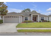 Charming single-story home features a well-manicured lawn and a welcoming front entrance with a 2 car garage at 6523 Evergreen Park Dr, Lakeland, FL 33813