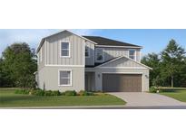 Two-story home featuring a gray exterior, two-car garage and well-manicured lawn at 1181 Hour Glass Rd, Lakeland, FL 33801