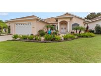 Charming single-story home featuring a lush front yard with landscaping and a two-car garage at 6442 Bendelow Dr, Lakeland, FL 33810
