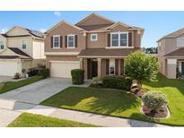 Charming two-story home featuring a well-manicured lawn and attached two-car garage at 460 Tess Ct, Orlando, FL 32834