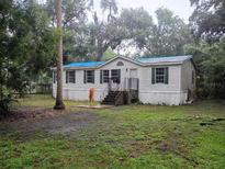 Traditional single-story home with lush landscaping and a welcoming front entrance at 6736 Cr 772, Webster, FL 33597