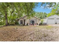 Charming single-story home featuring a welcoming front porch, beautifully landscaped yard and detached garage at 25302 Lido Ave, Sorrento, FL 32776