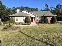 Charming single-story home with a well-maintained lawn and a welcoming red front door at 2528 Deerbrook Dr, Lakeland, FL 33811
