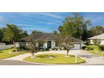 Beautiful one-story home features a circular driveway, manicured lawn, and mature landscaping at 2418 Se 23Rd St, Ocala, FL 34471