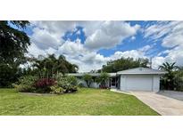 Charming single-story home featuring a lush front yard with tropical landscaping and a one-car garage at 1618 Pineberry St, Lakeland, FL 33803