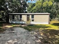 Tan home with a brown front door and well kept yard at 2434 Trenton E Rd, Lakeland, FL 33815