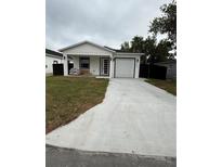 Newly renovated single-story home featuring a pristine white exterior, modern black trim, and an inviting one-car garage at 209 W 6Th St, Lakeland, FL 33805