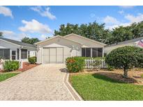 Charming single-story home with a well-manicured lawn and colorful landscaping at 2121 Escobar Ave, Lady Lake, FL 32159