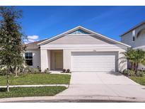 Charming single-Gathering home featuring a manicured lawn, two-car garage, and classic architectural details at 1038 Foreshore Ln, Haines City, FL 33844