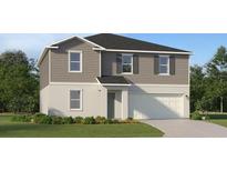 Charming two-story home featuring a gray siding, a white stucco, a two-car garage, and well-maintained landscaping at 2938 Pennachio Dr, Lake Wales, FL 33859