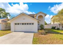 Charming two-story home featuring an attached two-car garage and well-manicured lawn under a bright blue sky at 728 Waterbridge Dr, Winter Haven, FL 33880