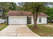 Charming single-story home featuring a 2-car garage, landscaped yard, and inviting curb appeal at 332 Sand Pine Trl, Winter Haven, FL 33880