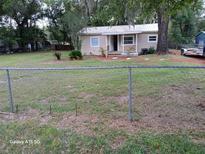 Charming single-story home with a metal roof, covered porch, and fenced yard at 2212 Ne 11 Ct, Ocala, FL 34470