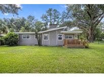 A beautiful landscaped backyard showcasing mature tree and lush lawn at 208 Se 32Nd Ave, Ocala, FL 34471