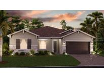 Charming single-story home featuring stone accents, a well-maintained lawn, and a two-car garage at 5431 Lewisham Dr, Davenport, FL 33837