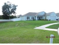 Beautiful one-story home showcasing a lush green lawn and a two-car garage at 206 Samantha Ave, Auburndale, FL 33823