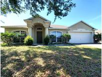 Charming single-story home with well-maintained landscaping and a two-car garage at 451 Peace Ct, Kissimmee, FL 34759