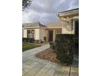 Inviting single-story home with manicured landscaping and a stone walkway to the front door at 9345 Se 171St Le Flore Ln, The Villages, FL 32162