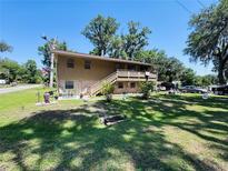 Two-story home with a spacious yard and deck, perfect for outdoor entertaining and enjoying a beautiful sunny day at 2073 Cr 428, Lake Panasoffkee, FL 33538