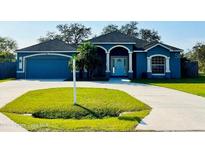 Charming home featuring a well-manicured lawn, two car garage and a front covered entry at 1895 Snapper Dr, Kissimmee, FL 34759