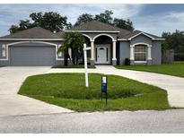 Charming single-story home with a well-manicured lawn, a two-car garage and inviting front entrance at 1895 Snapper Dr, Kissimmee, FL 34759